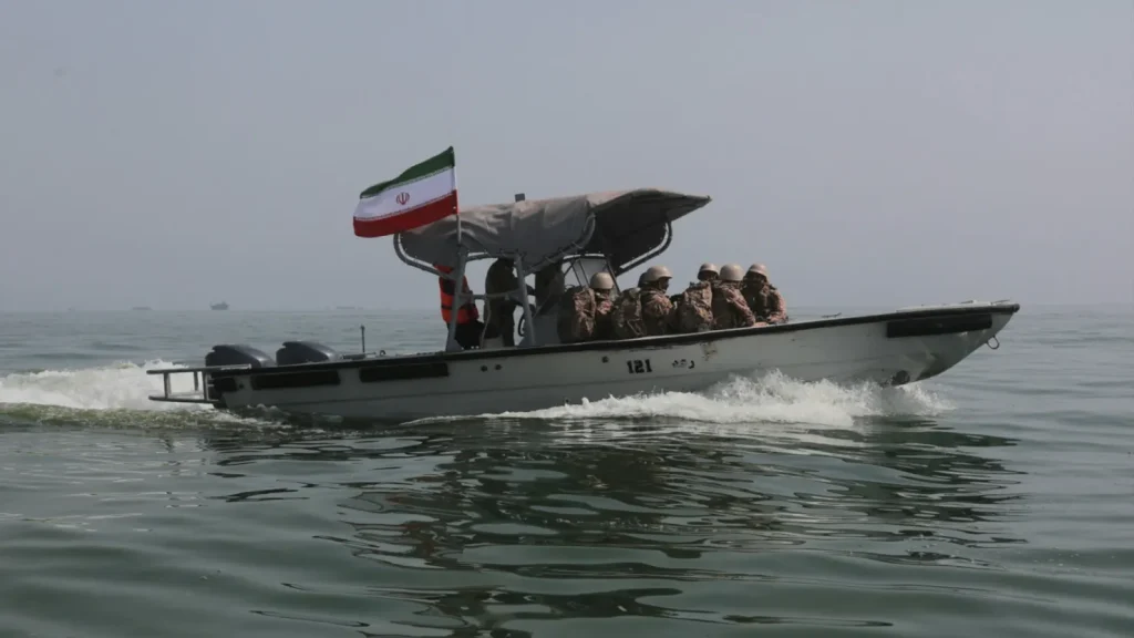 Cargo ships sailing through the Strait of Hormuz amid rising tensions and reported maritime attacks near Iran