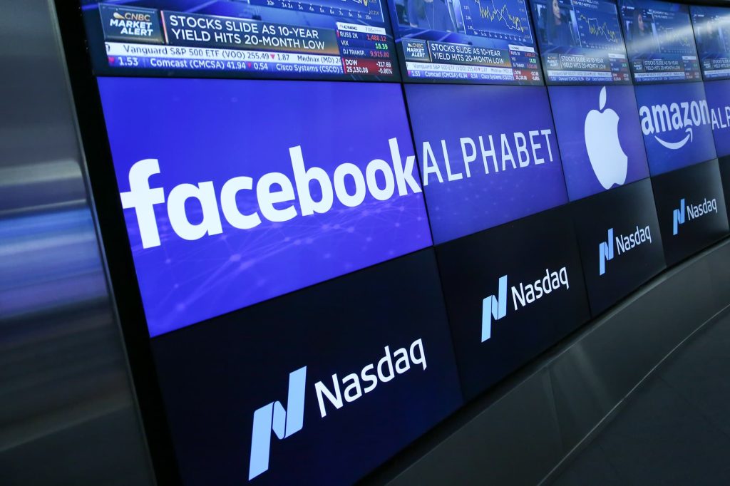 An aerial view of a massive modern data center facility surrounded by industrial cooling infrastructure and power lines.